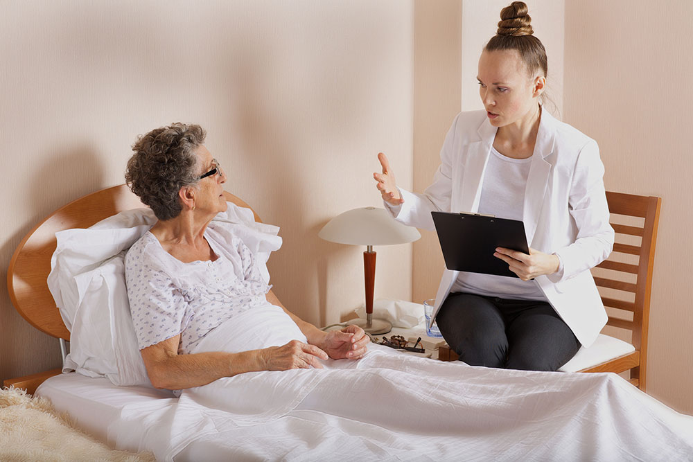 Caregiver visiting elderly woman to discuss care and safety Senior woman sitting with a visiting caregiver or social worker providing support and discussing care