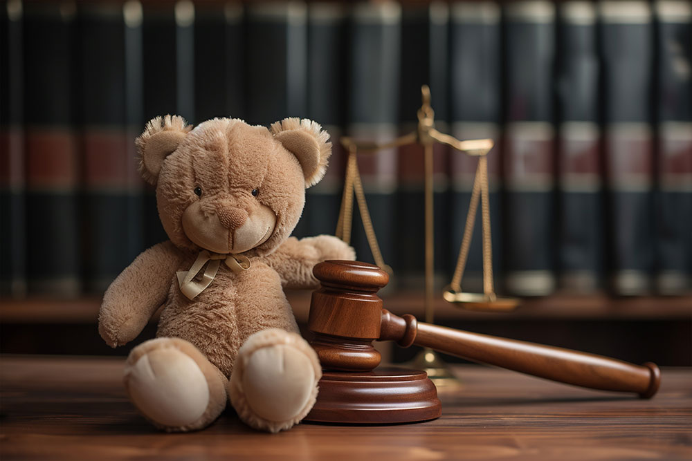 Legal action for defective children’s toys and furniture Judge’s gavel beside a teddy bear in a courtroom, symbolizing defective children’s toy and furniture lawsuits in Maryland